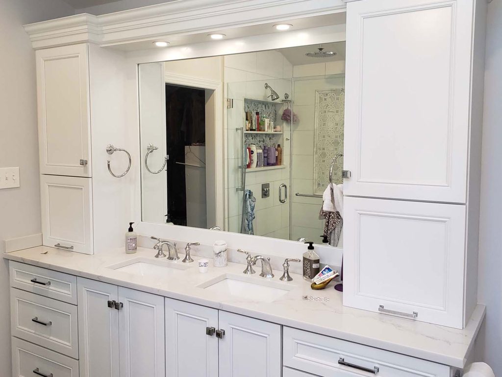 Large home bathroom sink with cabinets, drawers, and mirror.